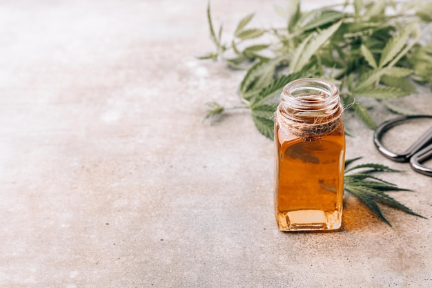 Olio di CBD Olio di canapa di canapa in bottiglia di vetro e foglie di cannabis Terapie alternative Spazio di copia