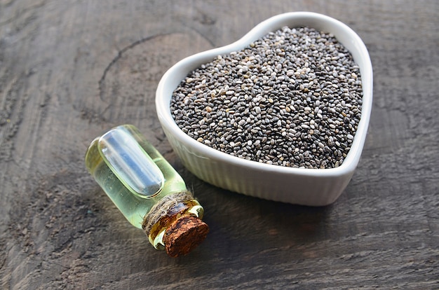 Olio di chia con semi di chia in una ciotola bianca. Olio di semi di chia biologico. Concetto di cibo, superfood o cura del corpo sano.