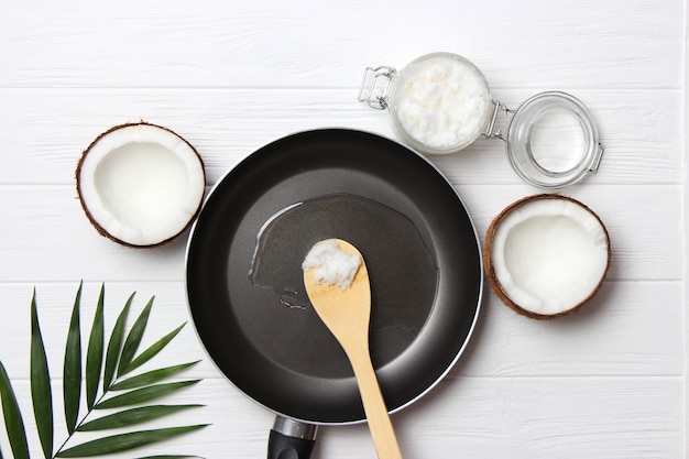 Olio di cocco e una padella su un primo piano della tavola di legno