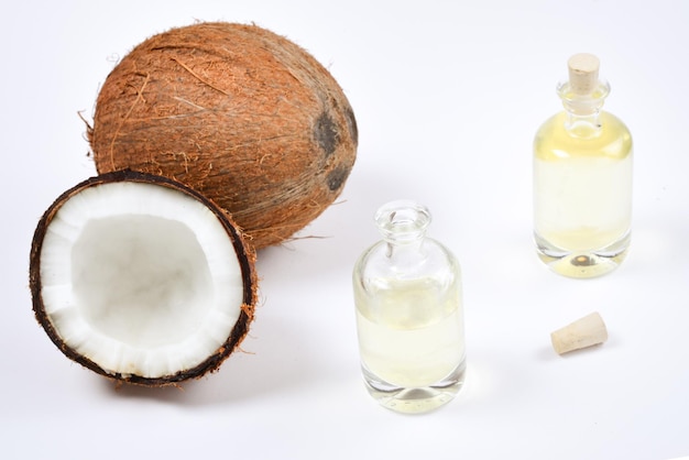 Olio di cocco naturale in bottiglie su sfondo bianco