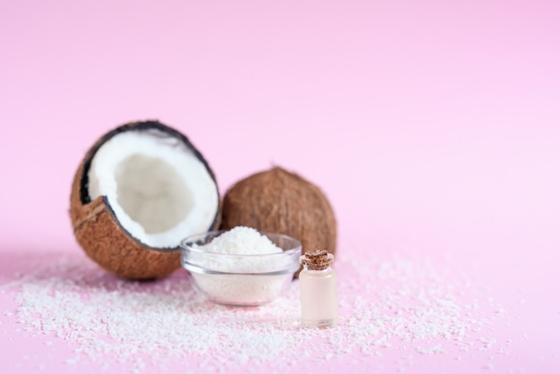 Olio di cocco per la cura del corpo nel concetto cosmetico organico su sfondo rosa.