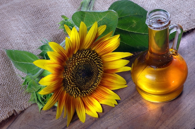 olio di girasole e un fiore di girasole sul tavolo.