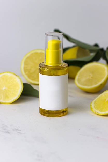 Olio di limone su fondo bianco circondato da limoni