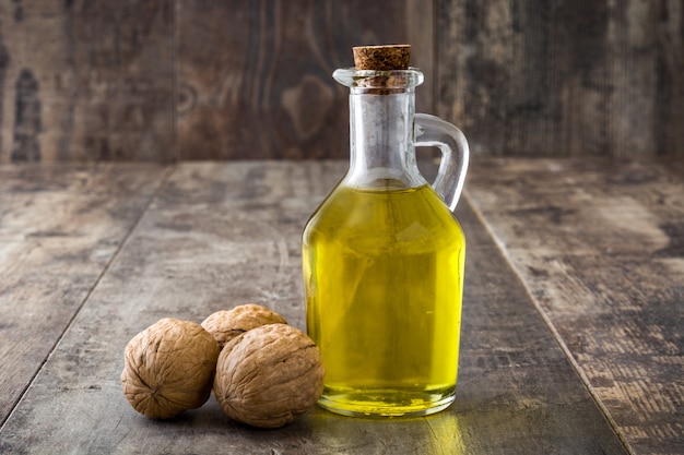 Olio di noci in barattolo sulla tavola di legno