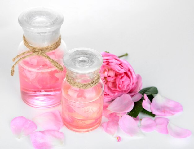 Olio di rose in bottiglia isolato su bianco