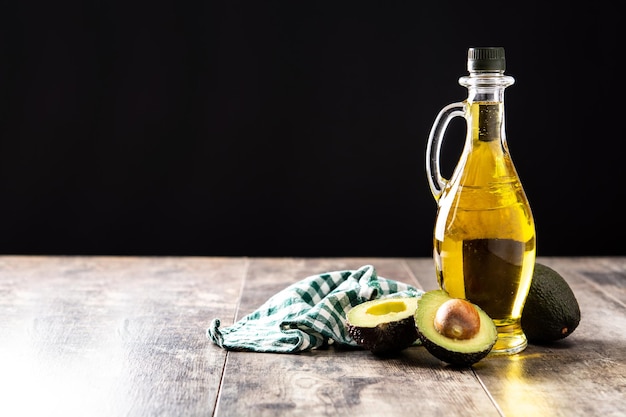 Olio e avocado fresco maturo su tavola di legno rustica