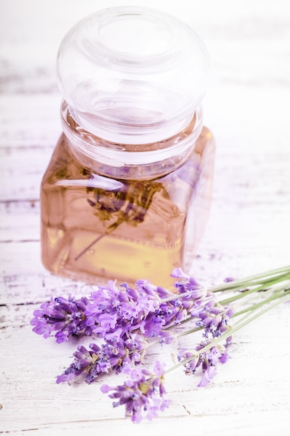 Olio essenziale di lavanda e fiori di lavanda freschi su uno sfondo