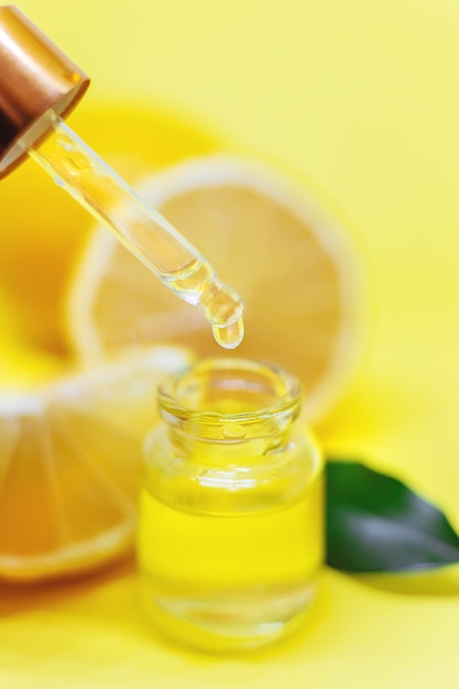 Olio essenziale di limone su sfondo giallo. Messa a fuoco selettiva.