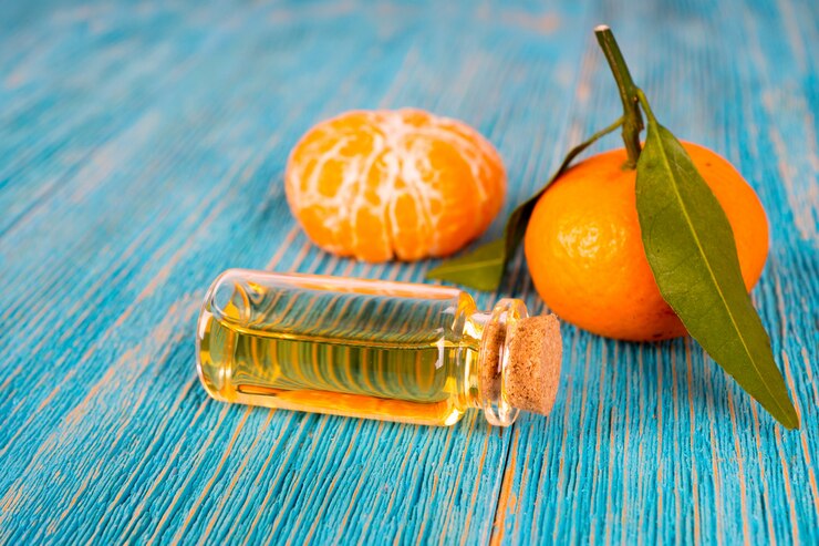 Olio essenziale di mandarino con frutti sul tavolo di legno turchese