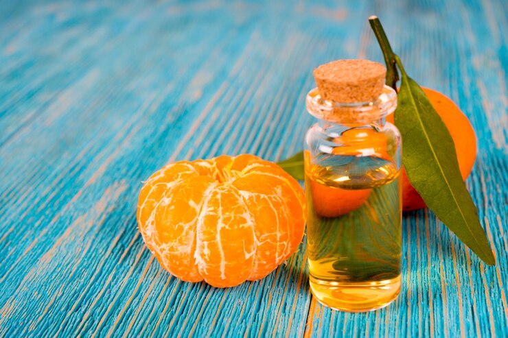 Olio essenziale di mandarino con frutti sul tavolo di legno