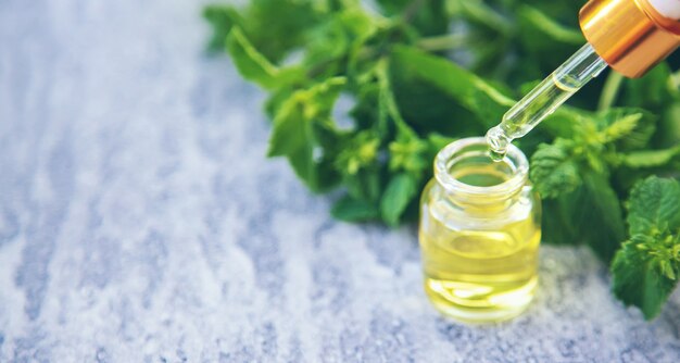 Olio essenziale di menta piperita in una piccola bottiglia. Messa a fuoco selettiva. natura.