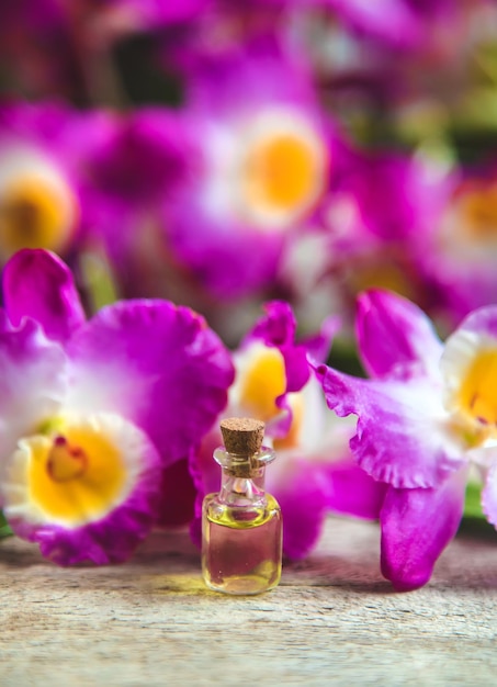 Olio essenziale di orchidea in una piccola bottiglia. Messa a fuoco selettiva.