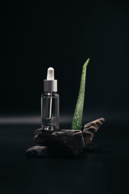 Olio essenziale per la cura della pelle del viso una bottiglia di vetro con una pipetta su una pietra Cura della pelle