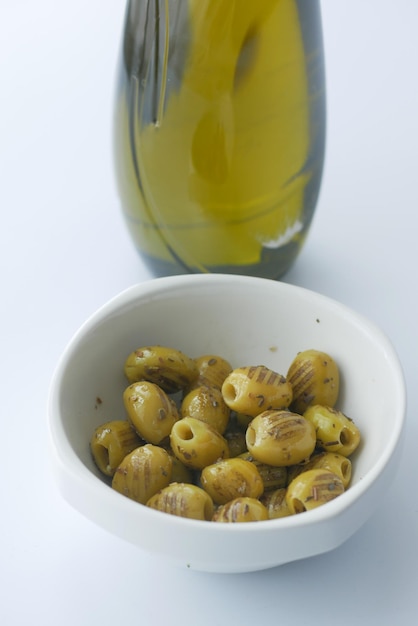 Olive alla griglia turche con vasetto di oliva e olio sul tavolo