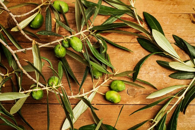 Olive e foglie di ulivo su un tavolo di legno