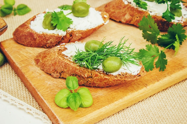 Olive e formaggio su uno sfondo bianco. panini. messa a fuoco selettiva.