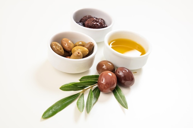 Olive e olio d'oliva su sfondo bianco