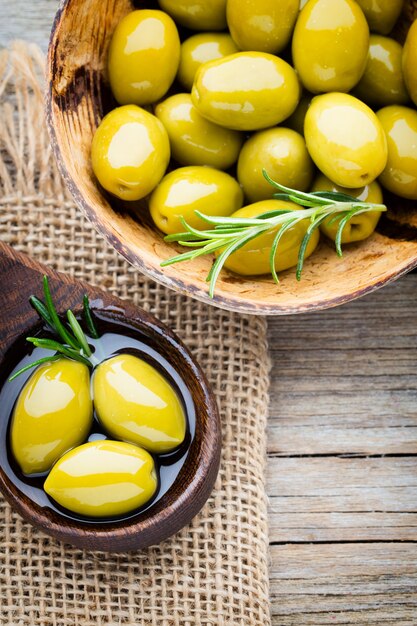 Olive fresche e tavola grigia. Olive in ciotola e cucchiaio.