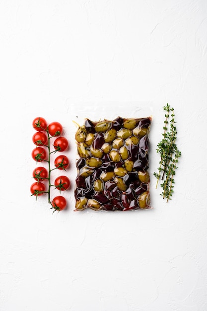 Olive greche in confezione di plastica, su sfondo di tavolo in pietra bianca, vista dall'alto piatta, con spazio di copia per il testo