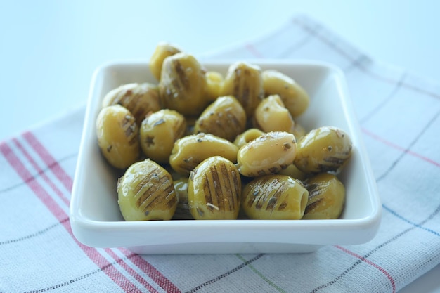 Olive grigliate in un piatto bianco sul tavolo