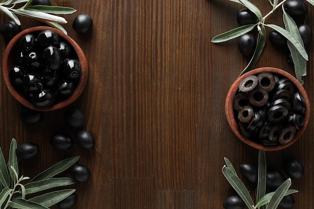 Olive in ciotole di legno sullo spazio di fondo in legno per il testo