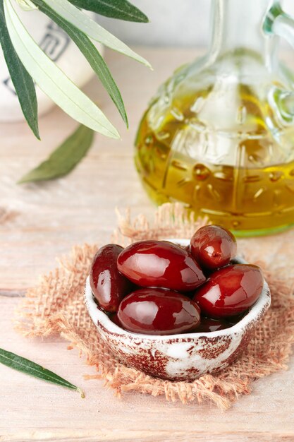 Olive lucide rosse nere nere di Kalamata delle specialità gastronomiche in ciotola ceramica sulla tavola di legno