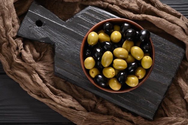 Olive nere e verdi su fondo nero di legno scuro