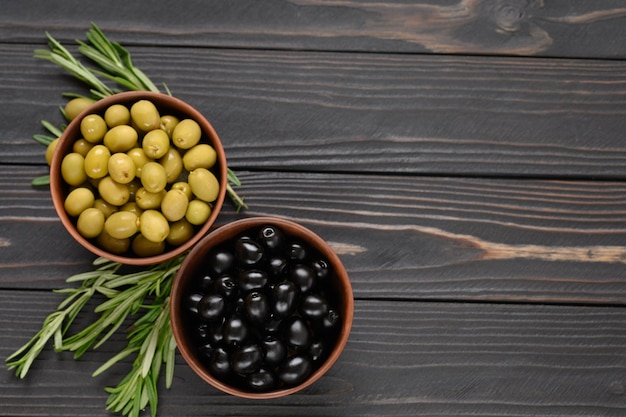 Olive nere e verdi su fondo rustico di legno scuro