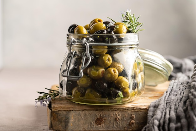 Olive verdi e nere si mescolano in un barattolo di vetro Deliziose olive marinate