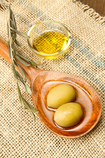 olive verdi fresche su cucchiaio e olio