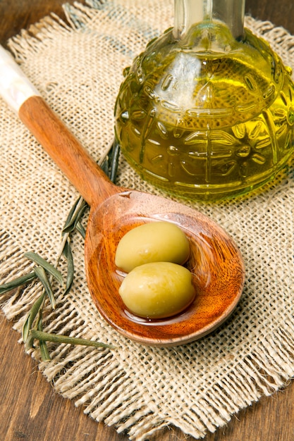 olive verdi fresche su cucchiaio e olio