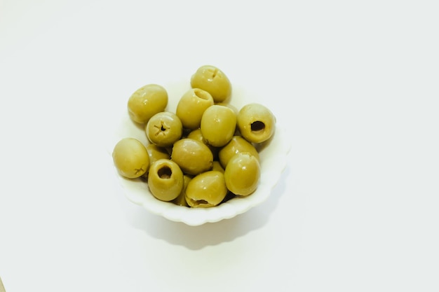 Olive verdi in scatola in una ciotola bianca sul tavolo