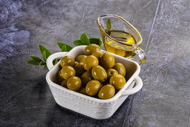 Olive verdi mature gustose con ramo e olio