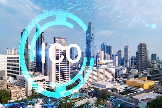 Ologramma dell'icona ICO sulla vista panoramica della città di Bangkok, il fulcro dei progetti blockchain in Asia Il concetto di moneta iniziale che offre Doppia esposizione