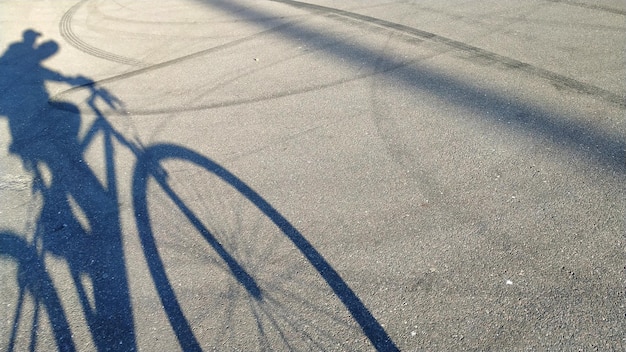 Ombra di una persona in bicicletta sulla strada