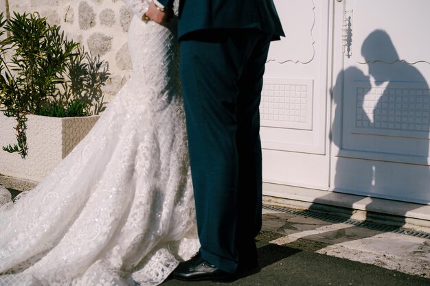 Ombre di quasi baciare la sposa e lo sposo sulla porta del primo piano della casa di pietra