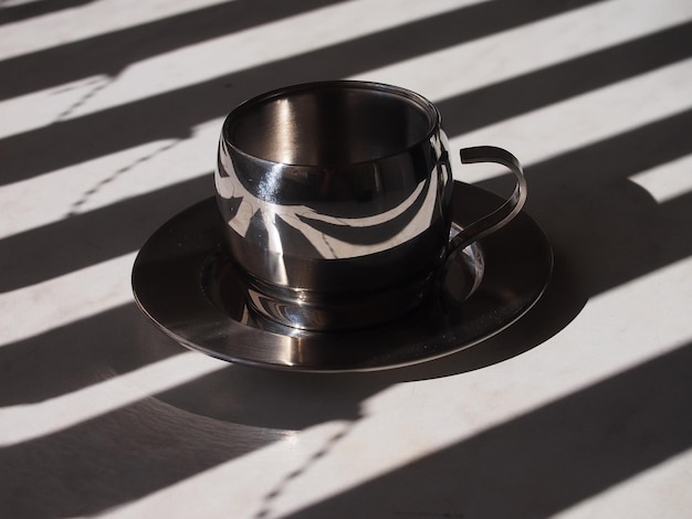 Ombre e una tazza di caffè in metallo