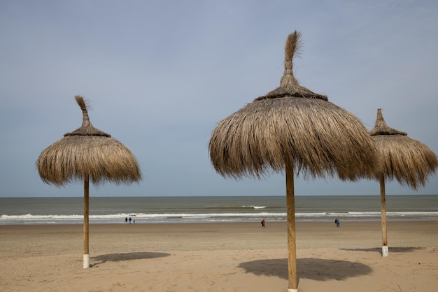 Ombrelli di canna su una spiaggia di sabbia deserta