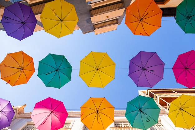 Ombrelli multicolori sono appesi per strada lungo le case contro il cielo