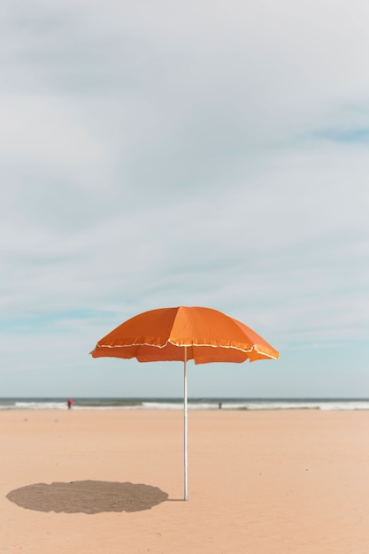 Ombrello arancione sul collage sulla spiaggia