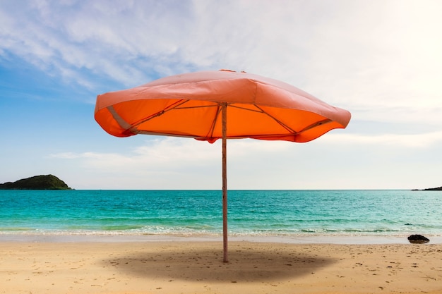 Ombrello arancione sul collage sulla spiaggia