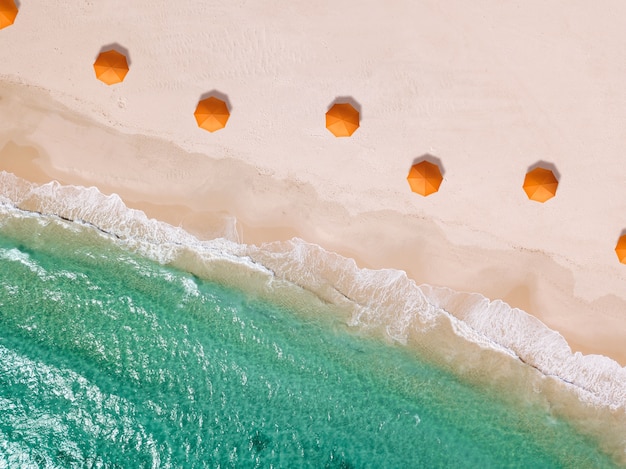 Ombrello arancione sul collage sulla spiaggia