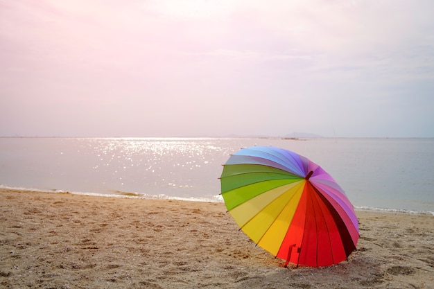 Ombrello colorato su sfondo spiaggia