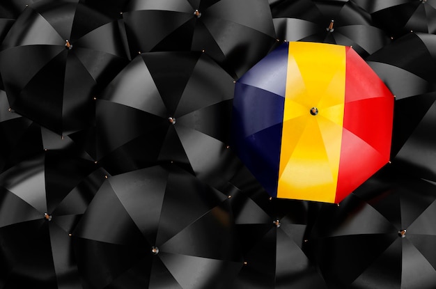 Ombrello con bandiera rumena tra ombrelli neri rendering 3D