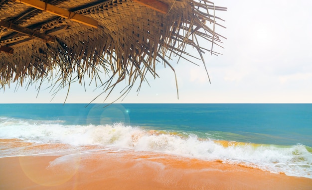 Ombrello di canna sulla spiaggia nell&#39;oceano