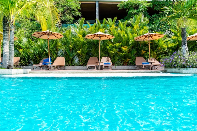 Ombrello e sedia intorno alla piscina in hotel e resort