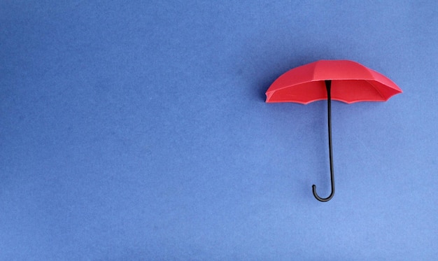 ombrello rosso con sfondo blu concetto di copertura assicurativa
