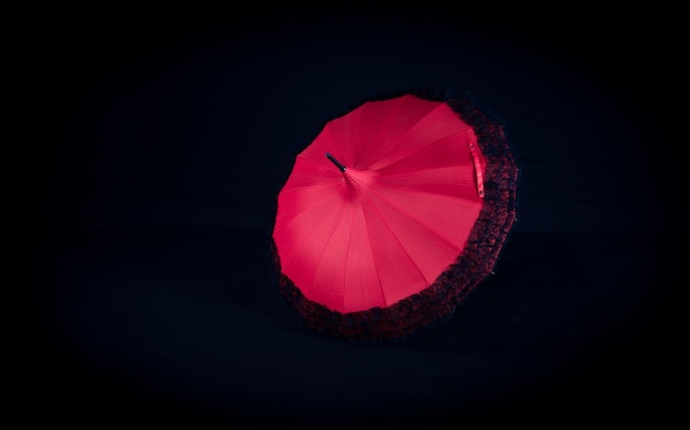 ombrello rosso vintage per donne su sfondo nero