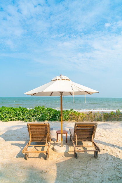 ombrellone con sedia a sdraio e oceano sullo sfondo del mare - vacanza e concetto di vacanza