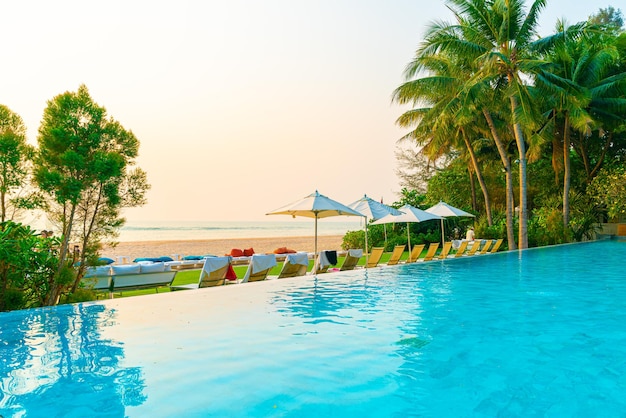 Ombrellone e sedia intorno alla piscina con vista sull'oceano mare per il concetto di viaggio per le vacanze